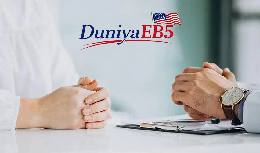Close-up of hands on a table with documents about investment projects, under the DUNIYAEB5 logo.